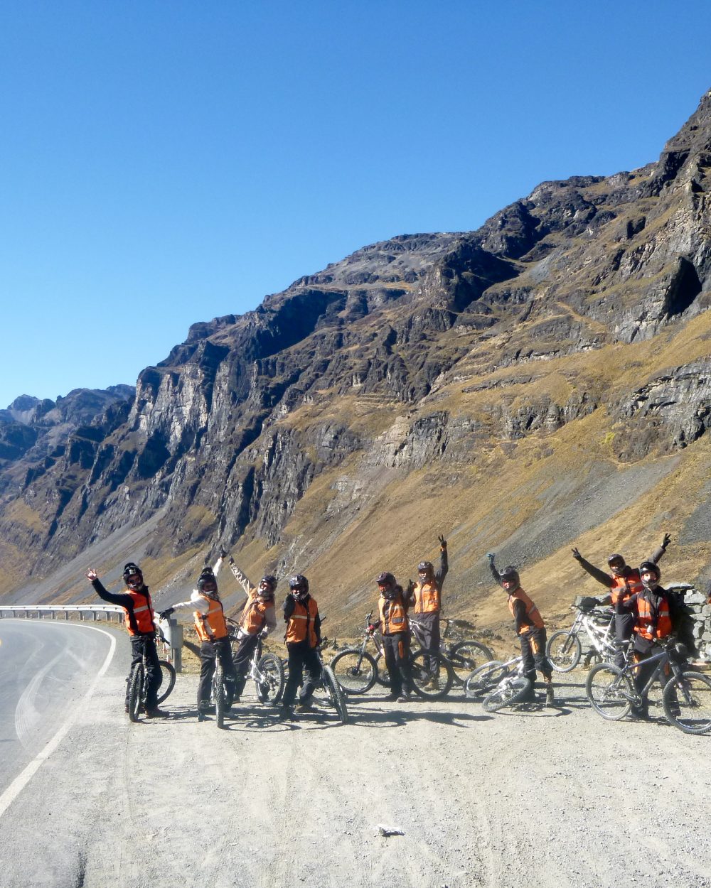 Groupe de vététistes sur la route au départ de l'Altiplano, face aux montagnes andines, Route de la Mort, Bolivie